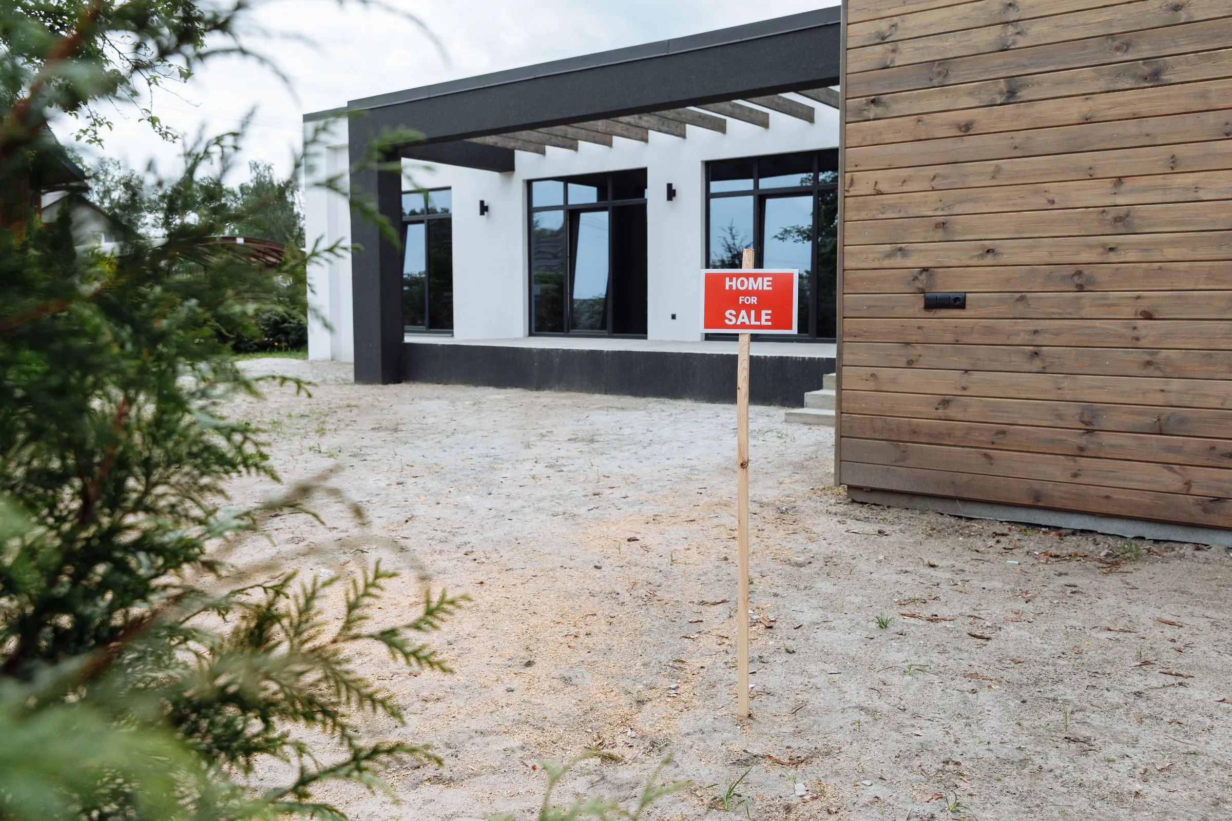 Casa moderna con cartello vendesi, a richiamare il valore immobiliare.