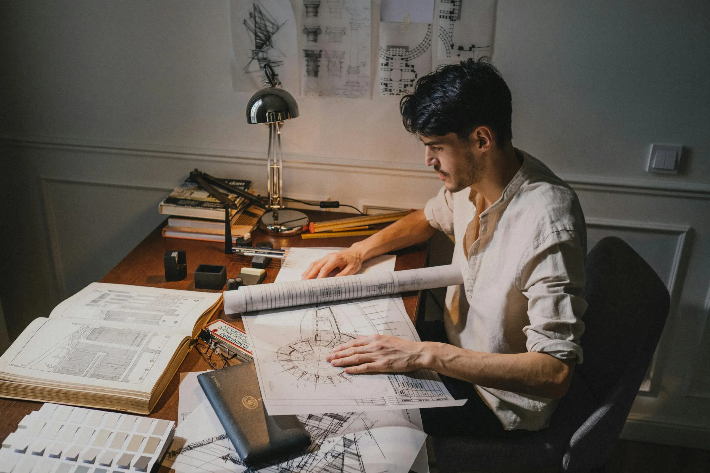 Architetto al lavoro alla scrivania su un progetto.