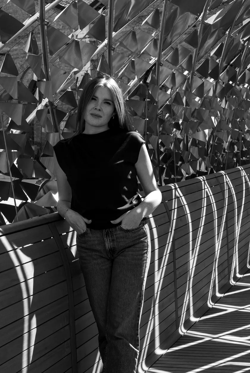 Laura Antonello, architetto, davanti a una facciata rivestita di elementi metallici